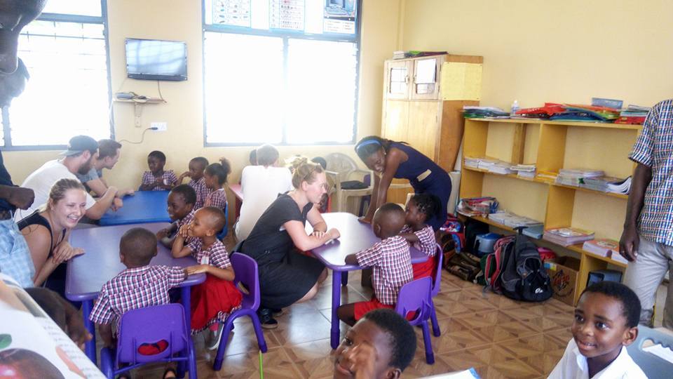 A PROaid Africa volunteer warmly engaging with preschool children at a community school