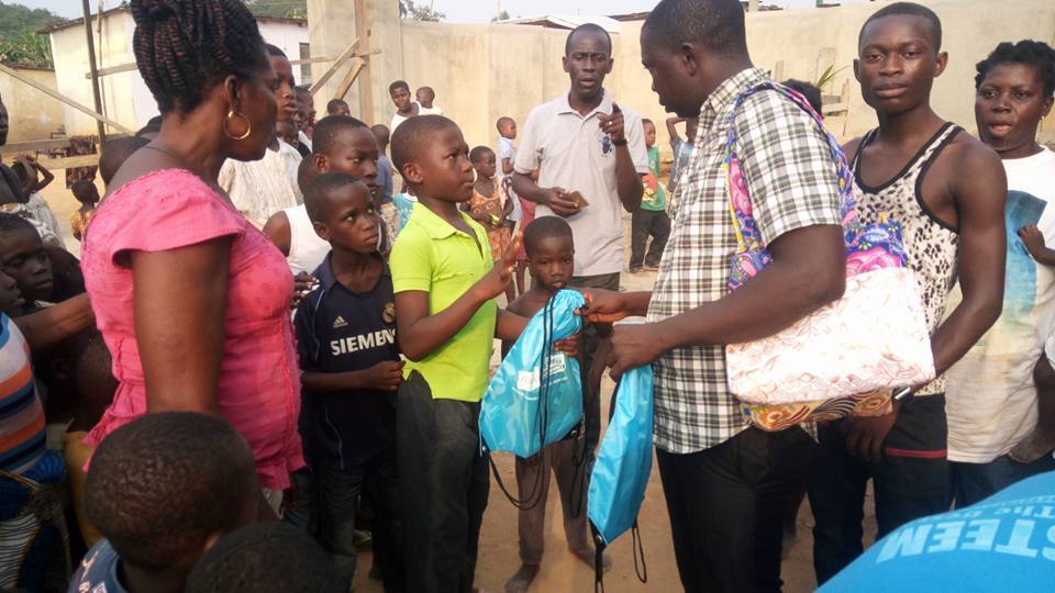 Children joyfully receiving donation bags at the Essaman community outreach event