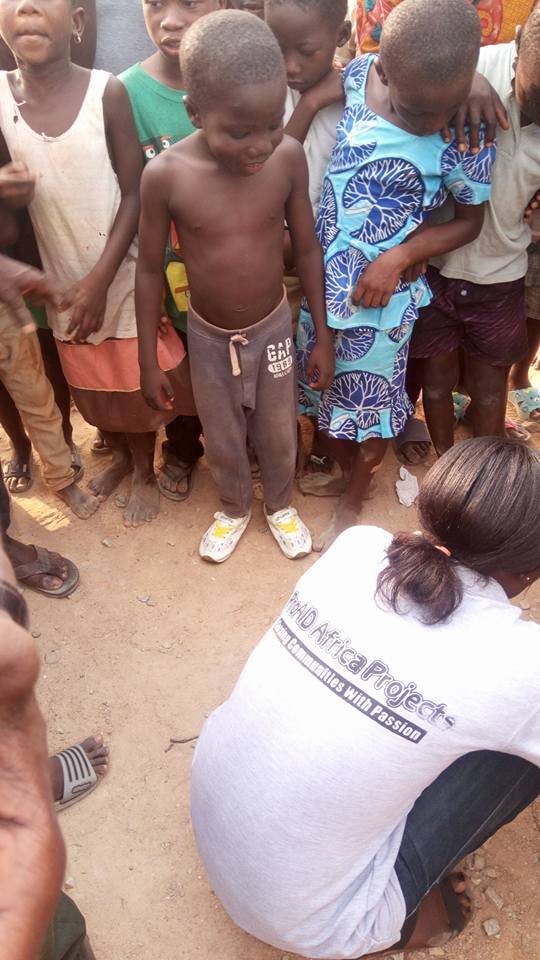 Volunteer fitting shoes on child during outreach
